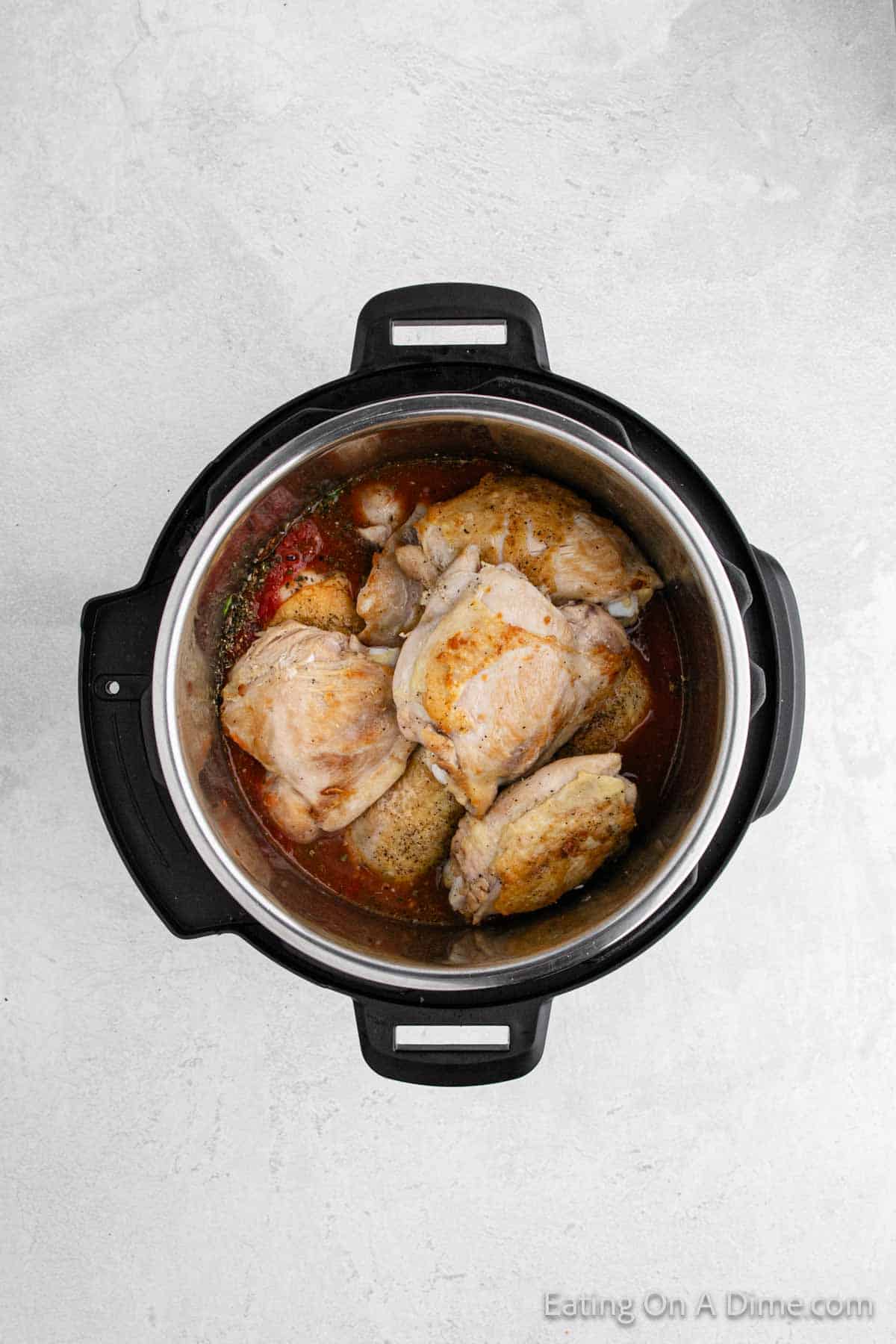 Topping the sauce with cooked chicken in the instant pot