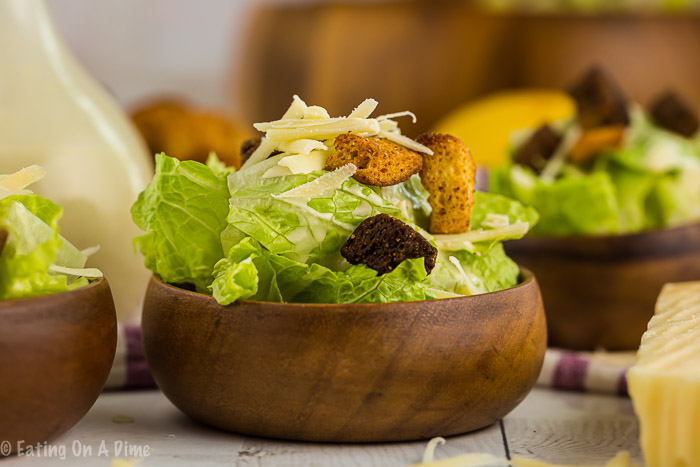 Enjoy this light and delicious Easy Caesar Salad Recipe at home for a tasty meal. You can eat it plain or add chicken to make it a full meal. Learn how to make a caesar salad for a healthy dinner. This classic recipe is the best. Try the original homemade dressing. #eatingonadime #caesarsaladrecipe #recipeeasy #dressings 