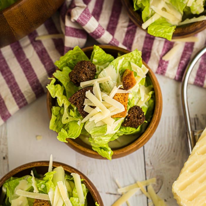 Enjoy this light and delicious Easy Caesar Salad Recipe at home for a tasty meal. You can eat it plain or add chicken to make it a full meal. Learn how to make a caesar salad for a healthy dinner. This classic recipe is the best. Try the original homemade dressing. #eatingonadime #caesarsaladrecipe #recipeeasy #dressings 