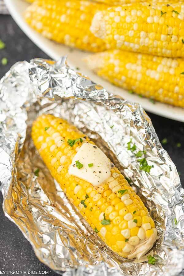 1 corn on the cob on a piece of foil topped with butter in the middle. 