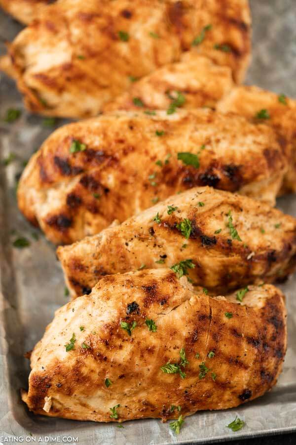 Grilled chicken breasts on a silver platter. 