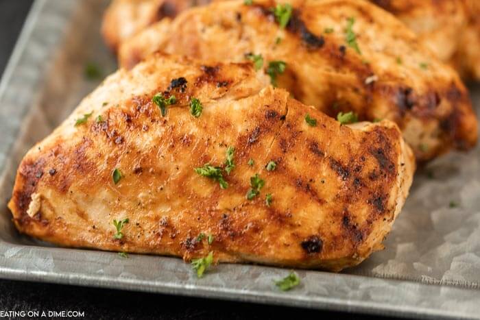 Grilled chicken breasts on a silver platter. 