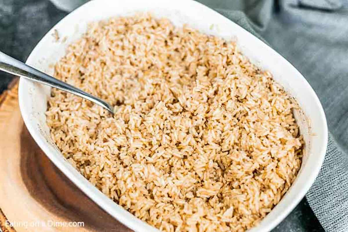 The brown rice cooked in a large microwave safe container, seasoned with salt & pepper and fluffed with a fork.  