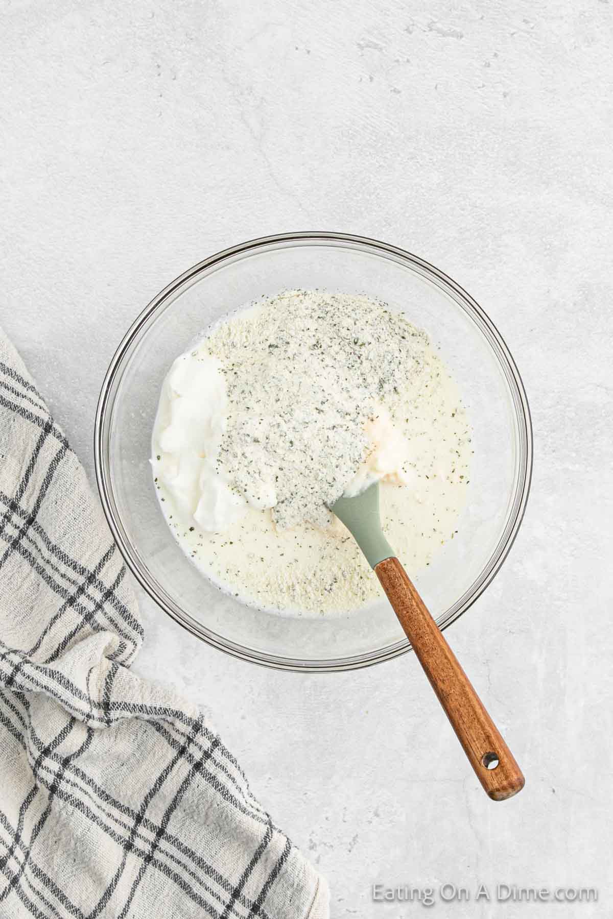 Combining the ranch dressing ingredients in a bowl with a wooden spoon