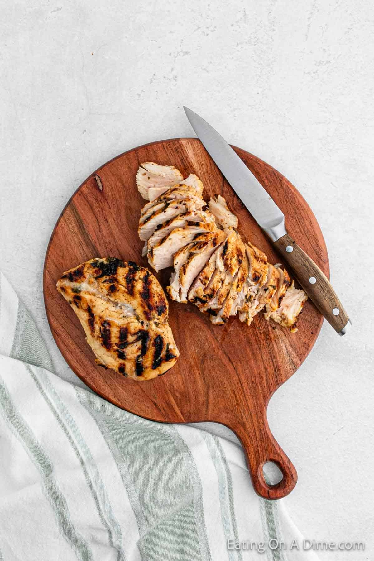 Slicing chicken on a cutting board with a knife
