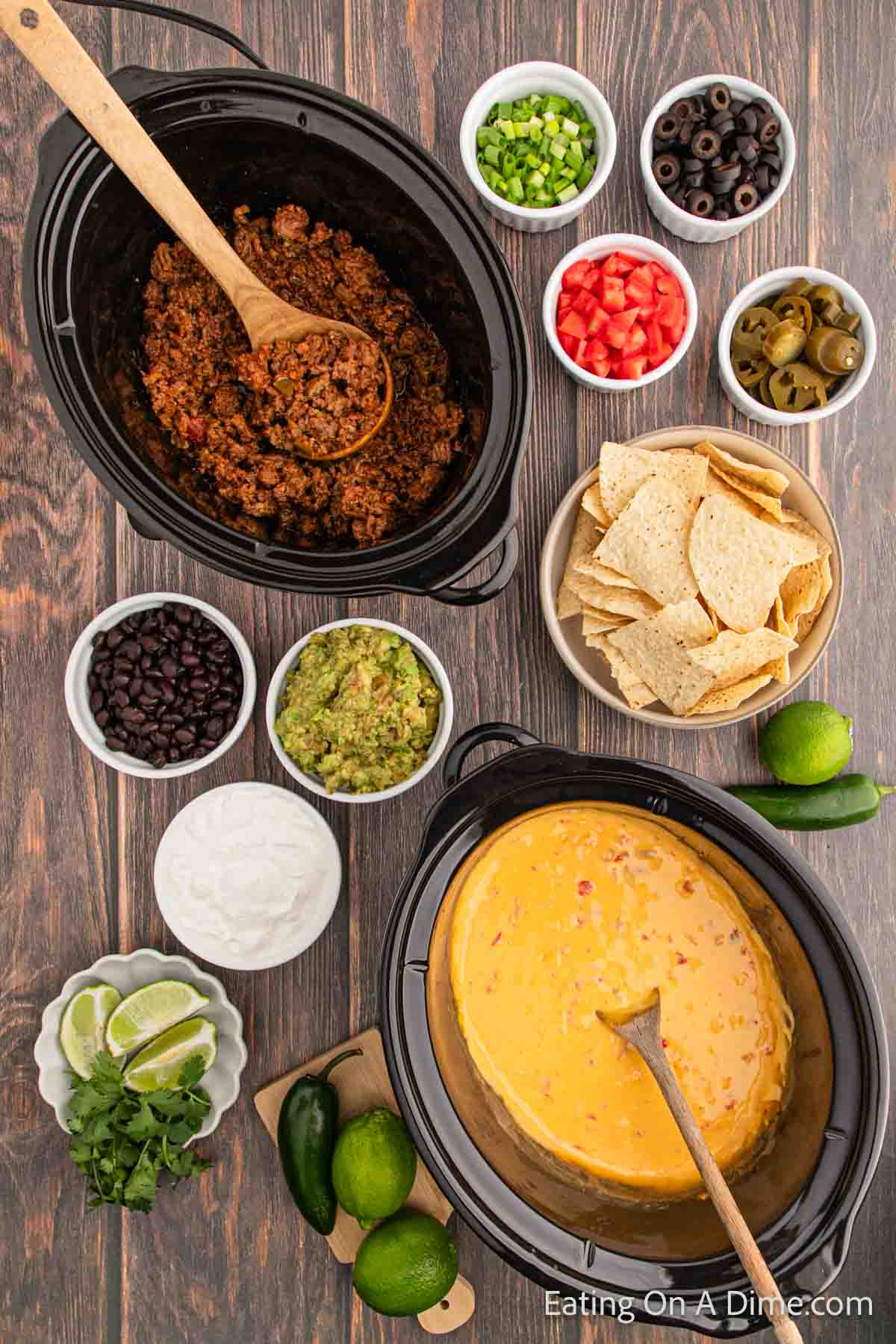 Nacho Bar setup with ground beef in the crock pot and cheese queso with bowls of toppings and chips