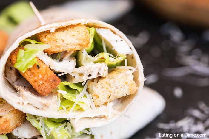 Chicken Caesar Salad Wrap recipe is a quick meal idea that includes everything you love about Caesar Salad. This grab and go wrap can be ready in 5 minutes for an easy lunch or dinner. Chicken Caesar Wraps are healthy and we show you the best way to prepare them. #Eatingonadime #chickencaesarsaladwraprecipe