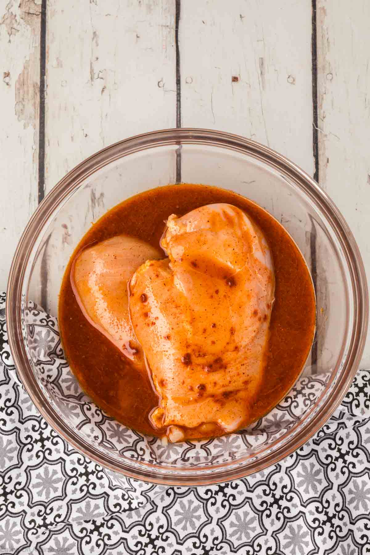 Chicken breast marinating in a bowl