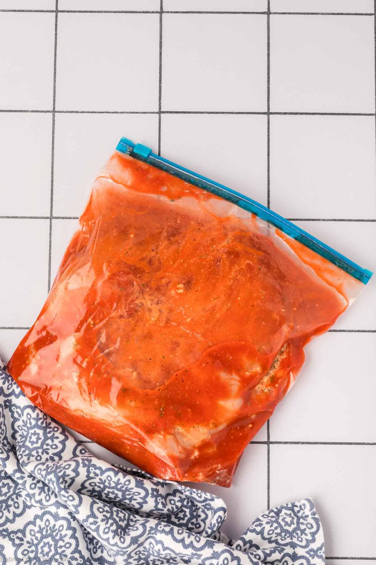 Marinating chicken in the buffalo sauce in a zip loc bag