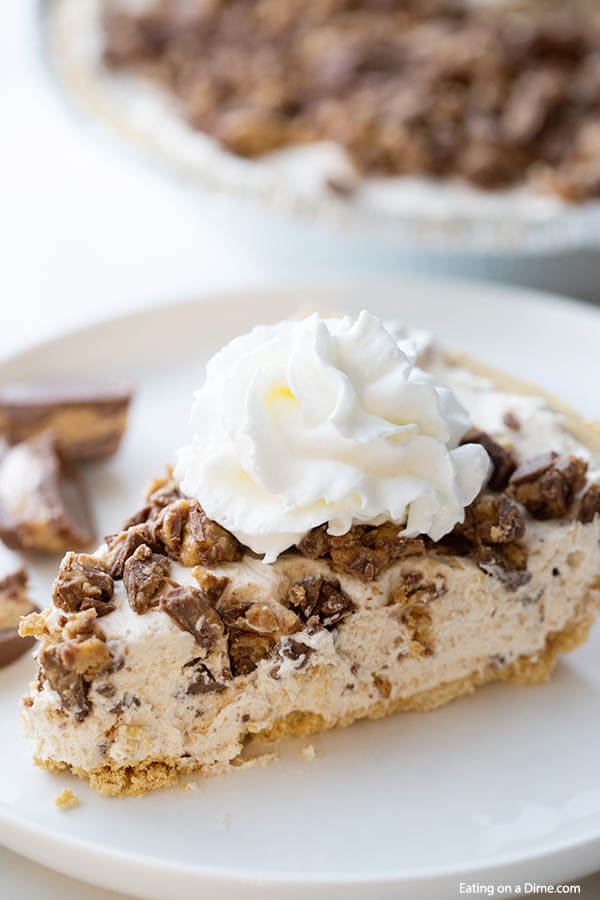 Close up image of a slice Reese's Peanut Butter candy Pie with cool whip. 