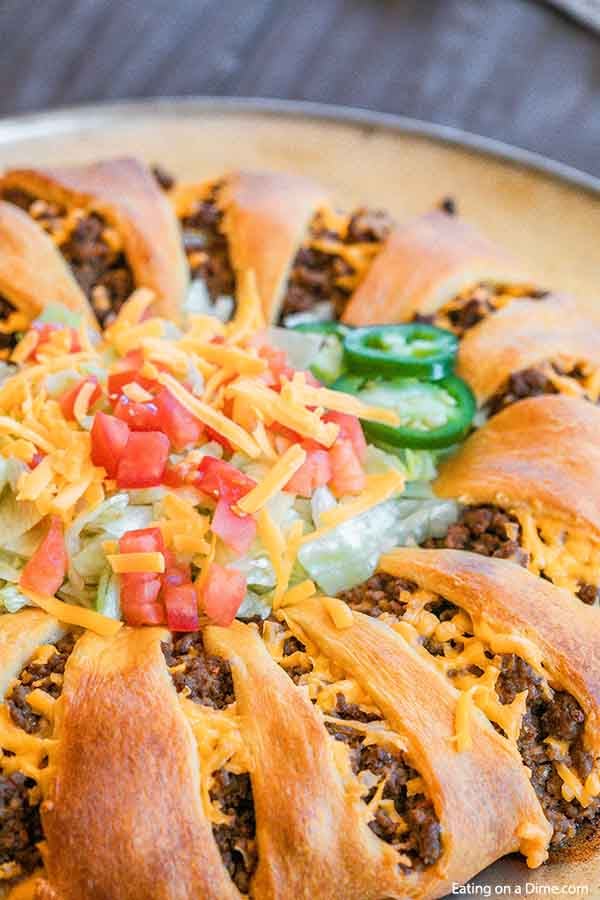 Taco Crescent Roll Ring topped with lettuce, tomato, shredded cheese and jalapenos. 