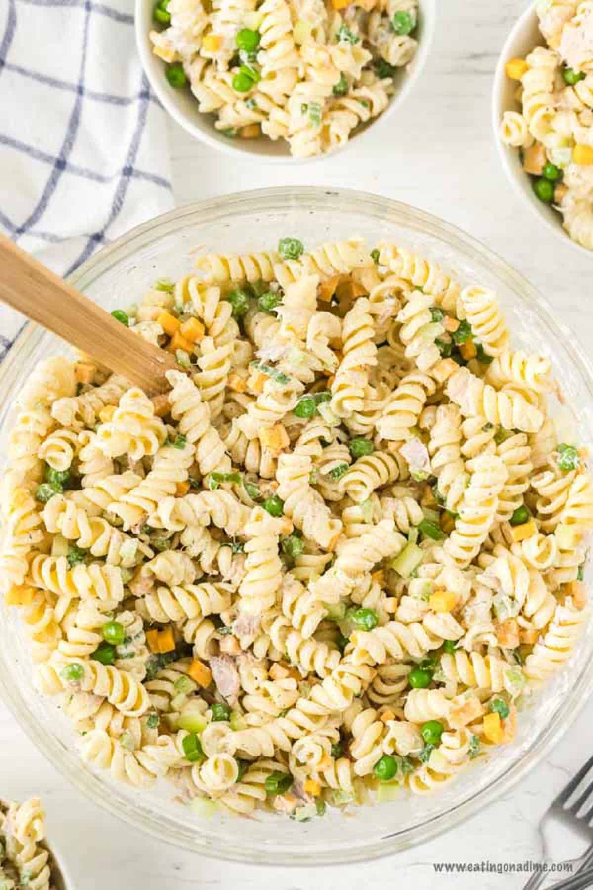 Tuna pasta salad recipe is a toss and go recipe full of protein, veggies and more. You will love the creamy pasta and delicious tuna for a quick meal. Tuna Pasta Salad in a bowl with a wooden spoon