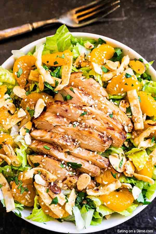 Enjoy this copy cat Panera bread Asian chicken salad at home for a delicious meal that is filling but not heavy. Tender chicken, almonds, mandarin oranges and more make Asian Sesame Chicken Salad healthy and delicious. Asian sesame chicken salad panera dressing is easy and tasty. Try panera bread asian sesame chicken salad. #eatingonadime #copycatpanerabreadasianchickensalad