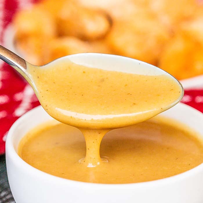 Close up image of chick fil a sauce with a serving on a spoon. 