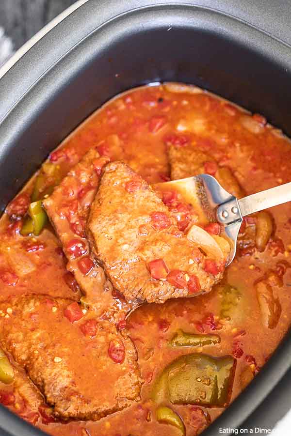 Turn inexpensive steak into tender Crockpot swiss steak. This slow cooker meal tastes like you spent all day in the kitchen but took minutes to prepare. 