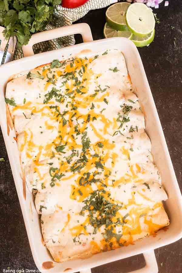 Green Chili Chicken Enchiladas bakes in only 20 minutes for an easy meal for weeknights. From the creamy and easy sour cream sauce to the green chili's, this dish is amazing. If you are looking for the best Mexican enchilada recipe, try this delicious white sauce over flour tortillas. #eatingonadime #greenchilichickenenchiladas #hatch #newmexico