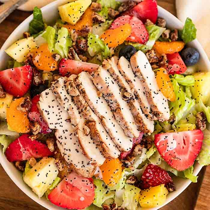 Panera Strawberry Poppyseed Salad is loaded with fruit and tender chicken. Delicious poppyseed dressing drizzled over the salad makes the dish even better. This copycat panera recipe is easy to make. Try this Panera Bread poppyseed salad with chicken today. #eatingonadime #panerastrawberrypoppyseedsalad