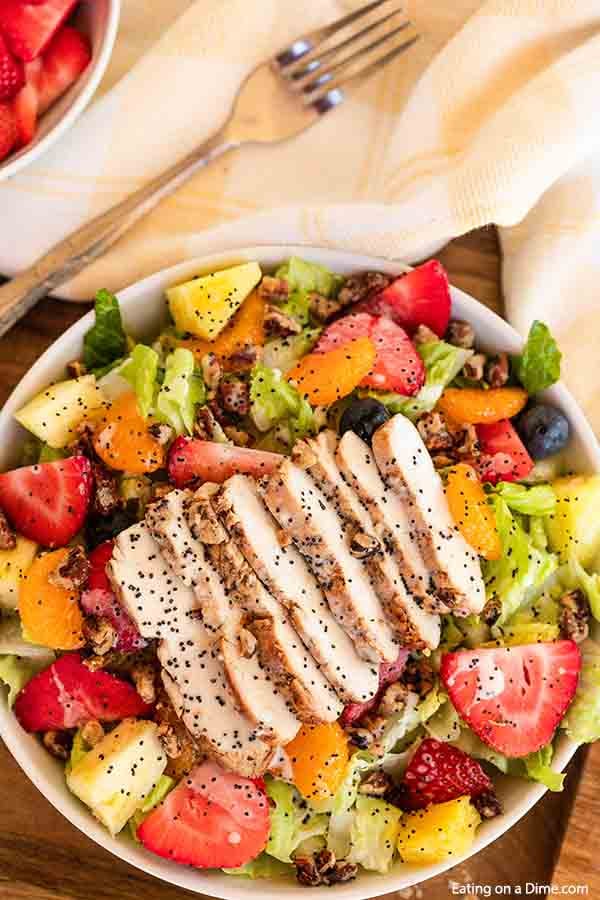 Panera Strawberry Poppyseed Salad is loaded with fruit and tender chicken. Delicious poppyseed dressing drizzled over the salad makes the dish even better. This copycat panera recipe is easy to make. Try this Panera Bread poppyseed salad with chicken today. #eatingonadime #panerastrawberrypoppyseedsalad