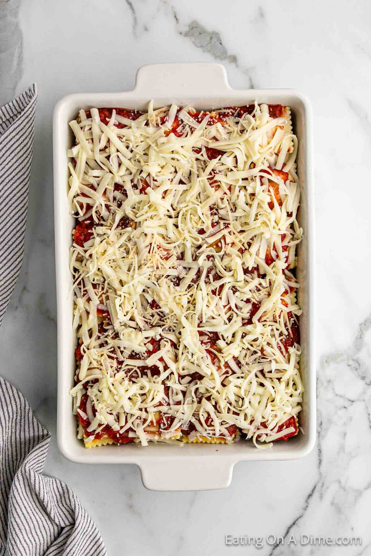 Topping the meat sauce and shredded cheese in a casserole dish