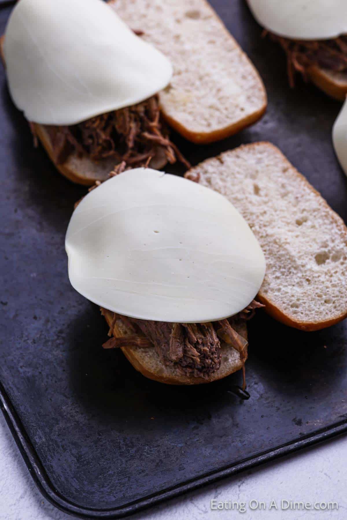 Shredded beef on hoagies topped with slice cheese