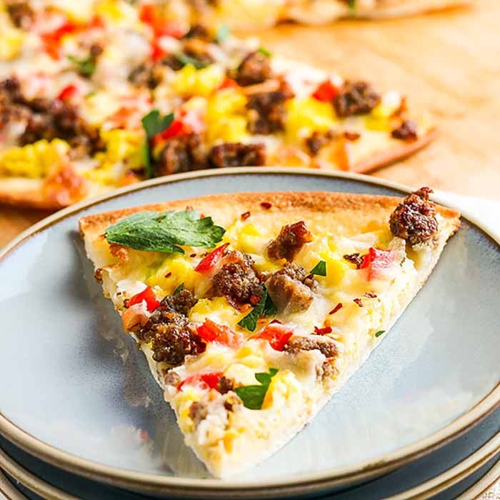 Enjoy pizza for breakfast when you make this easy and tasty sausage Breakfast pizza recipe. This simple breakfast idea bakes in just 20 minutes for the best school breakfast. Learn how to make homemade breakfast pizza for a great meal. #eatingonadime #breakfastpizzarecipe #recipeeasy