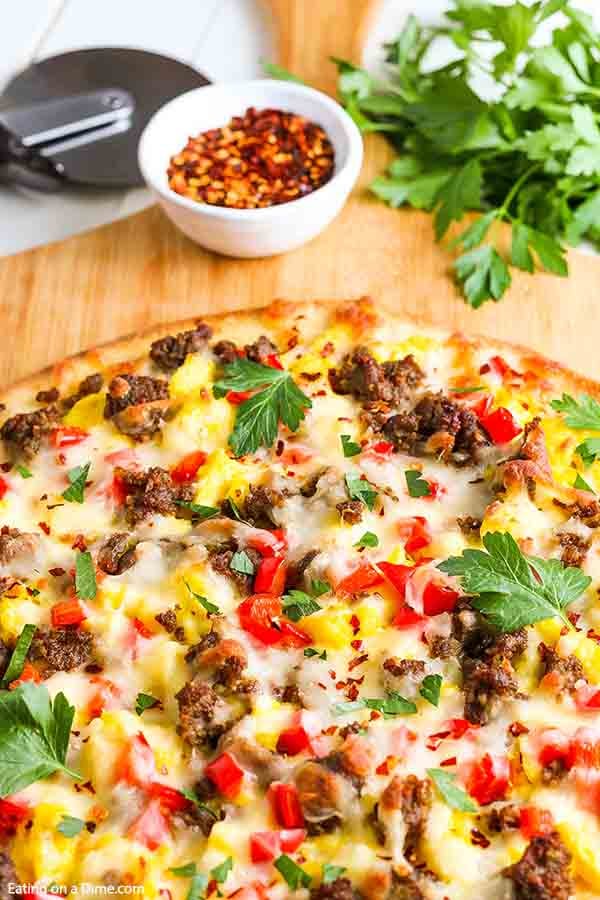 Enjoy pizza for breakfast when you make this easy and tasty sausage Breakfast pizza recipe. This simple breakfast idea bakes in just 20 minutes for the best school breakfast. Learn how to make homemade breakfast pizza for a great meal. #eatingonadime #breakfastpizzarecipe #recipeeasy