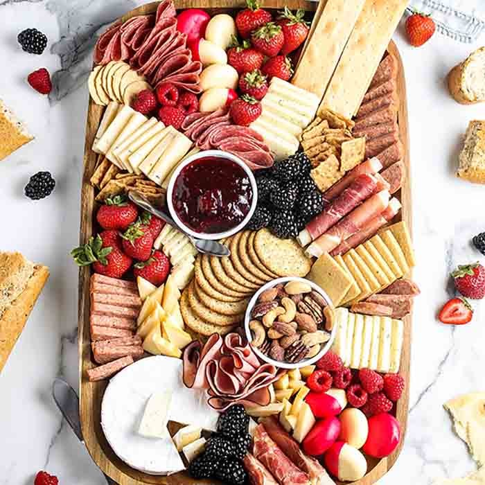 Overview of a completed Charcuterie Board with various fruits and crackers around it.  