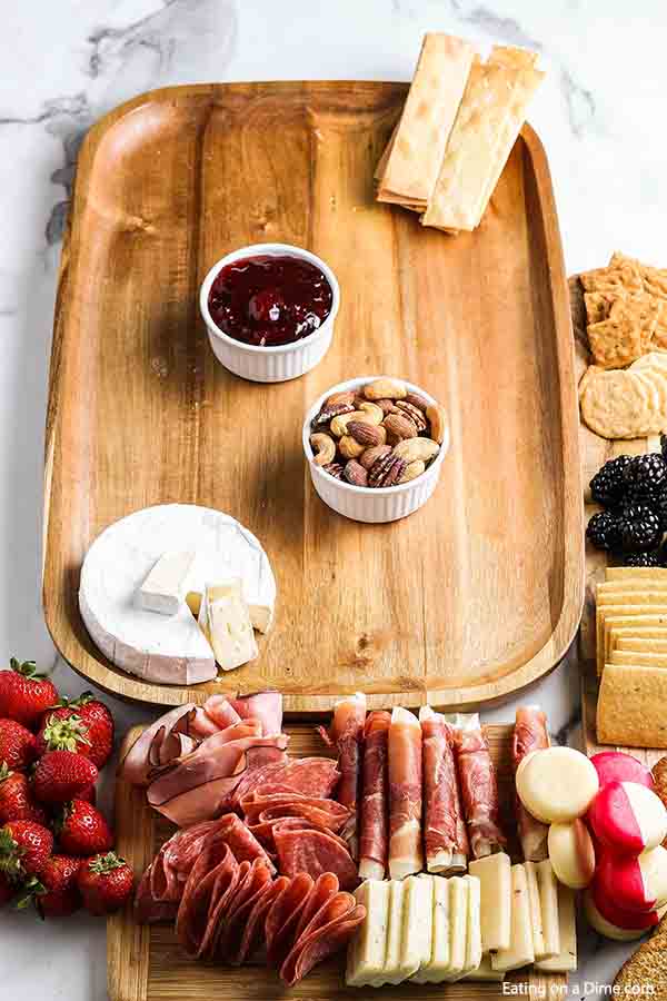 The small bowls and soft cheeses on the Charcuterie Board
