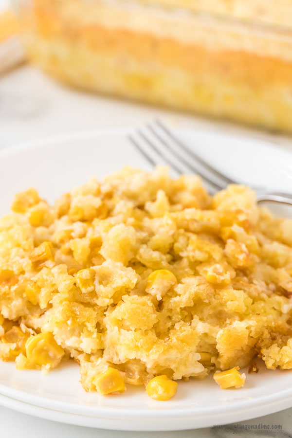 Close up image of corn casserole on a white plate with a fork. 