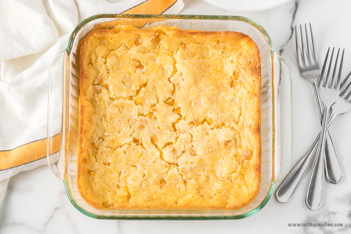 Close up image of corn casserole in a 8x8 pan with three forks. 