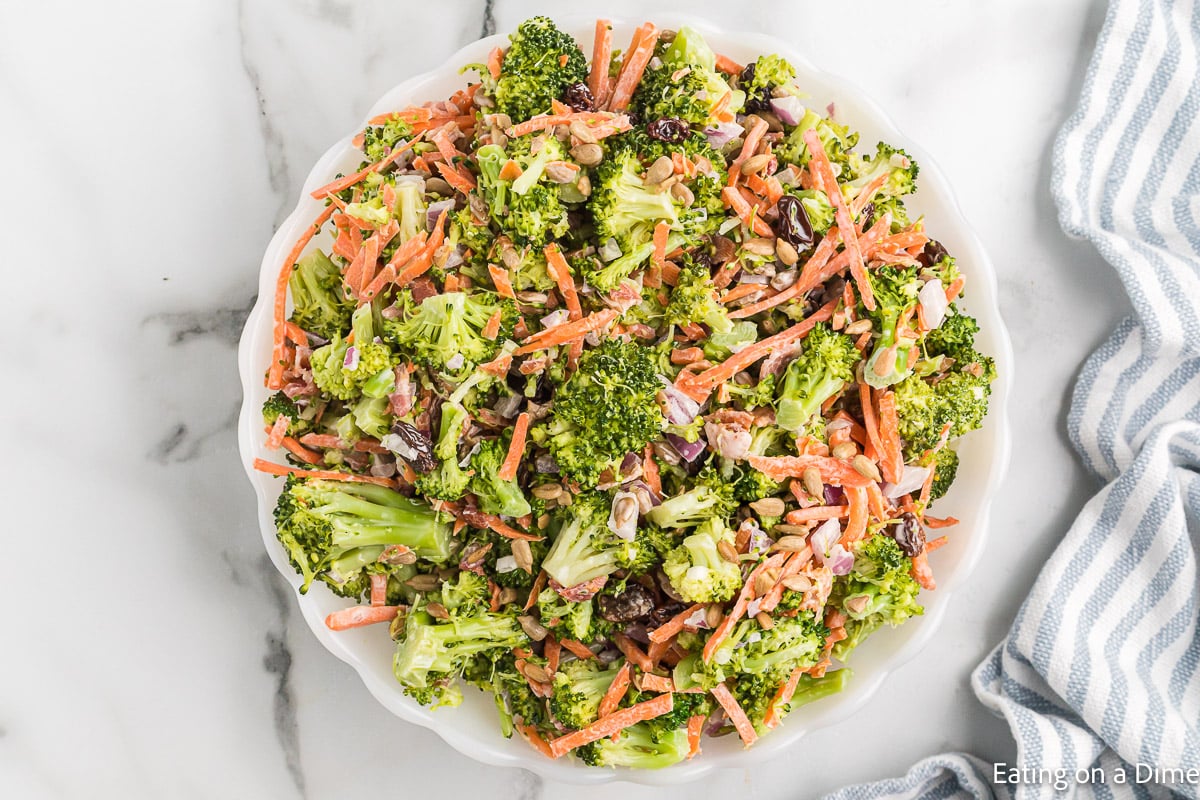 If you're loking for a quick, flavor packed side dish, this broccoli salad recipe is it! It's crunchy, sweet and salty all combined in one delicious salad. Broccoli Salad in a white bowl.