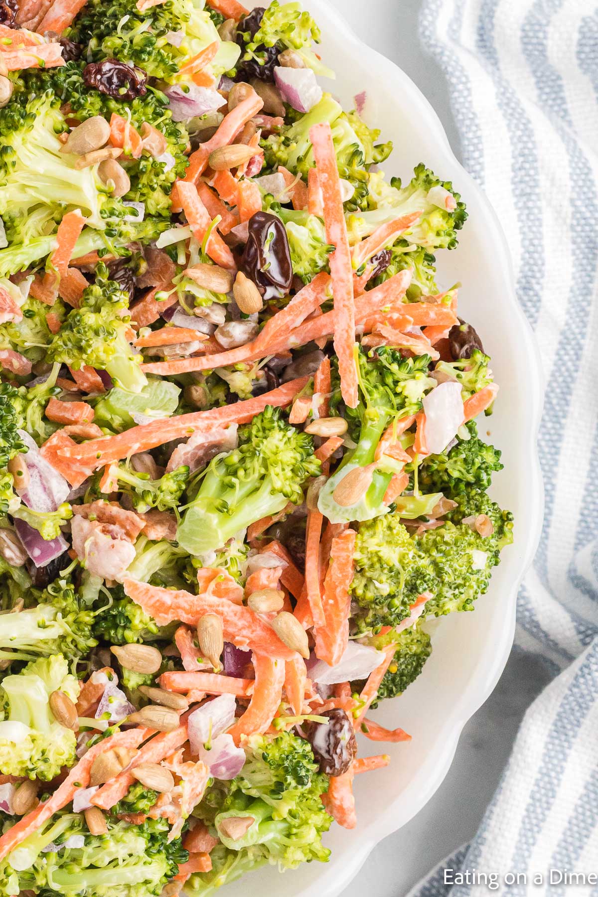 If you're loking for a quick, flavor packed side dish, this broccoli salad recipe is it! It's crunchy, sweet and salty all combined in one delicious salad. Creamy Broccoli Salad in a white bowl