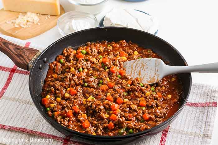 Hamburger casserole recipe is the best combination of hearty ground beef, pasta and a creamy sauce with sour cream. You can serve this quick and easy ground beef casserole with little prep work on busy nights. Hamburger Noodle Casserole is cheesy and one our favorite recipes. #eatingonadime #hamburgercasserolerecipe #groundbeefrecipeseasy #recipeseasy