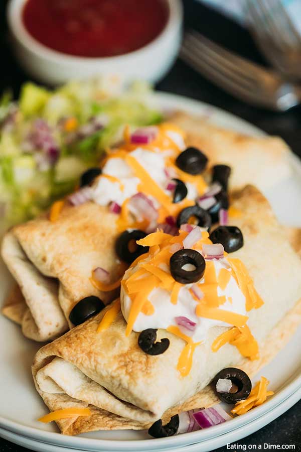 Your family will love this crispy and delicious Beef chimichanga recipe. Try baked beef and bean chimichangas for a simple and frugal meal. Beef bean and cheese chimichangas stretch your meat budget. Enjoy ground beef and bean chimichangas in minutes. #eatingonadime #beefandbeanchimichangas #beefbeanchimichangas