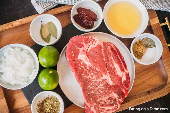 Ingredients needed for Barbacoa - beef roast, chipotle and adobo sauce, apple cider vinegar, bay leaves, cumin, onion, oregano, salt and pepper, limes, beef broth