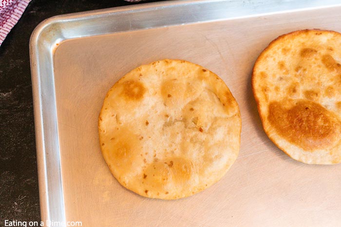 Close up image of two tortillas after being fried on a cookie sheet. 