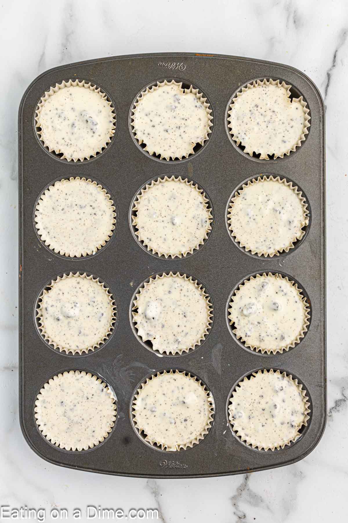 Placing the Oreo Cheesecake batter in muffin cups
