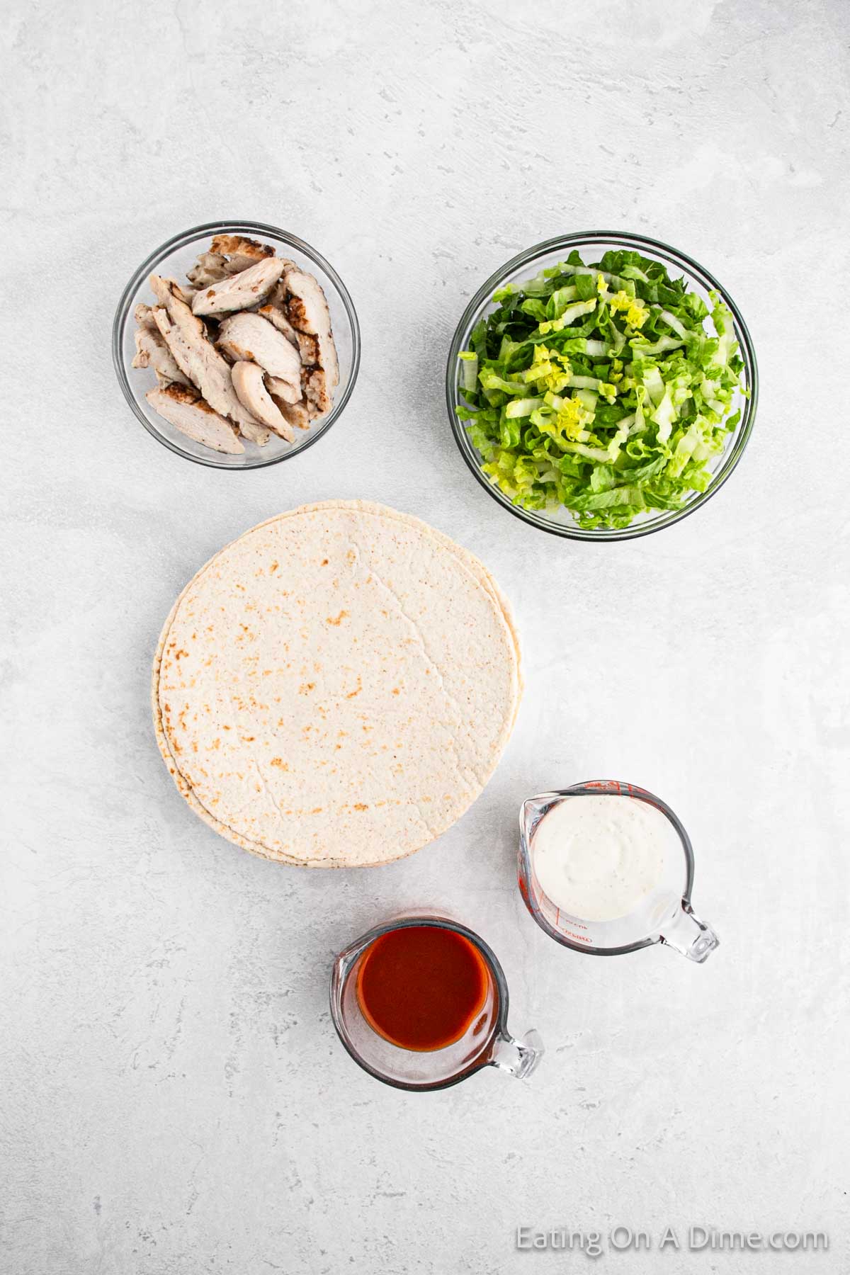 Bowl of grilled chicken strips, shredded lettuce, tortilla, buffalo sauce, ranch dressing