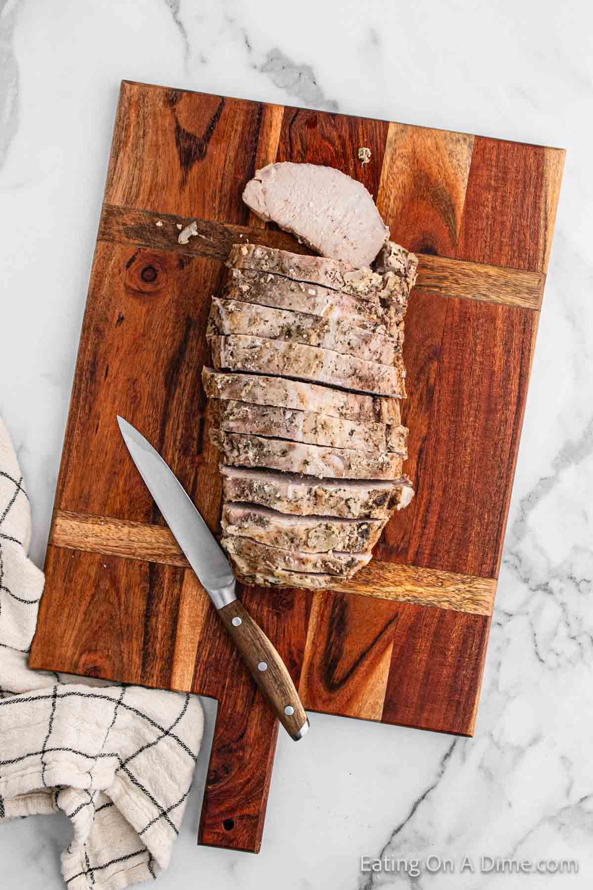 Slicing the pork loin on a cutting board with a knife