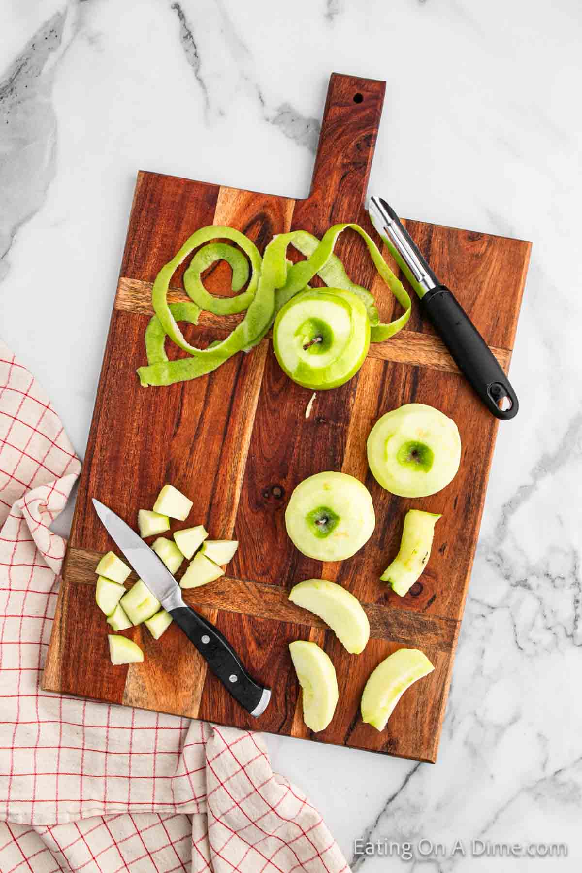 Peeling apples and dicing in bite size pieces on a cutting board