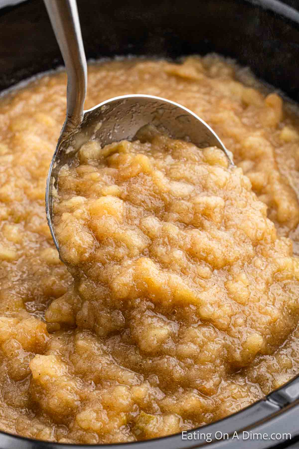Close up image of crockpot applesauce with a serving on a ladle