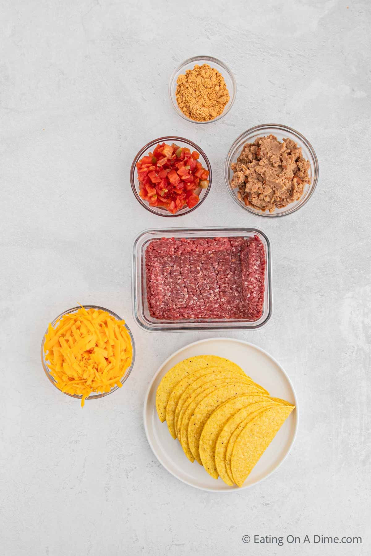 Oven baked tacos ingredients - ground beef, rotel, refried beans, taco seasoning, corn taco shells, cheese
