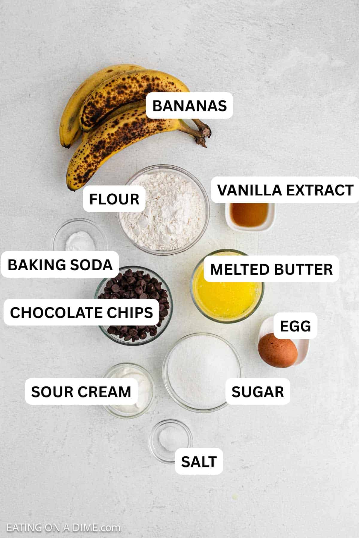 Ingredients needed for this recipe includes bananas, butter, egg, sugar, vanilla extract, baking soda, salt, flour, sour cream and chocolate chips.