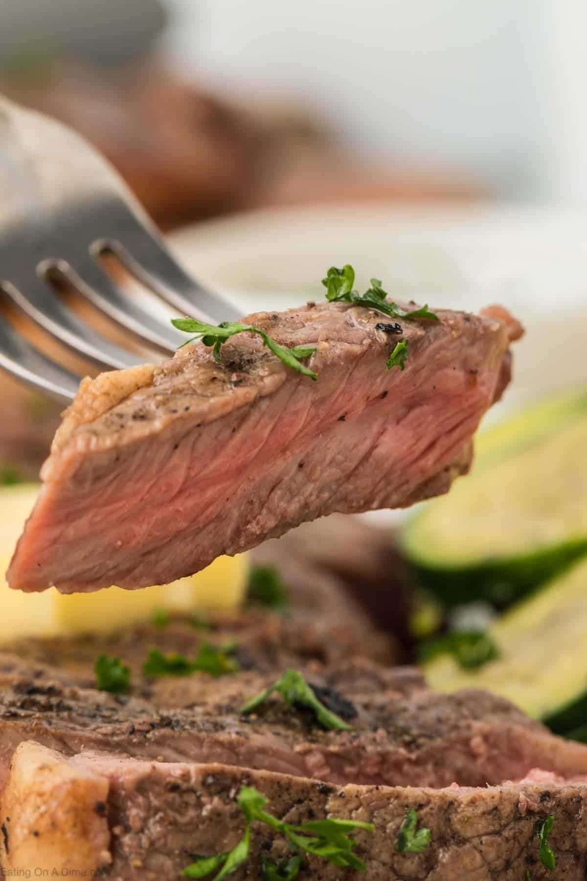 Close up image a bite of steak on a fork