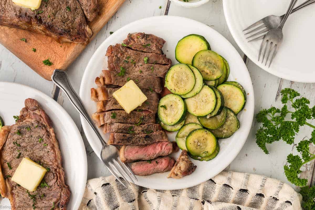 Grilled Steak sliced on a plate with a side of grilled zucchini