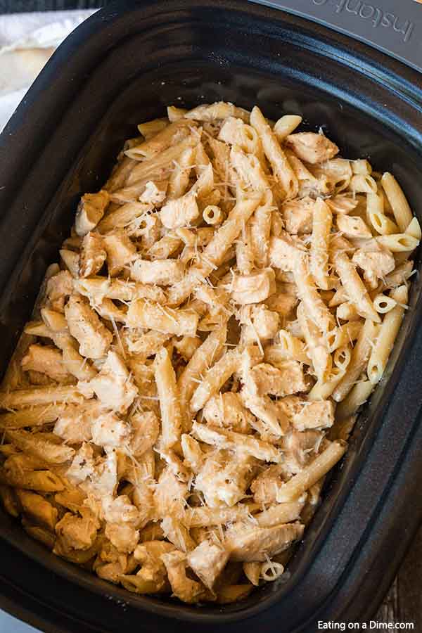 A crock pot full of this Creamy Alfredo Olive Garden Chicken Pasta in a large crock pot.  
