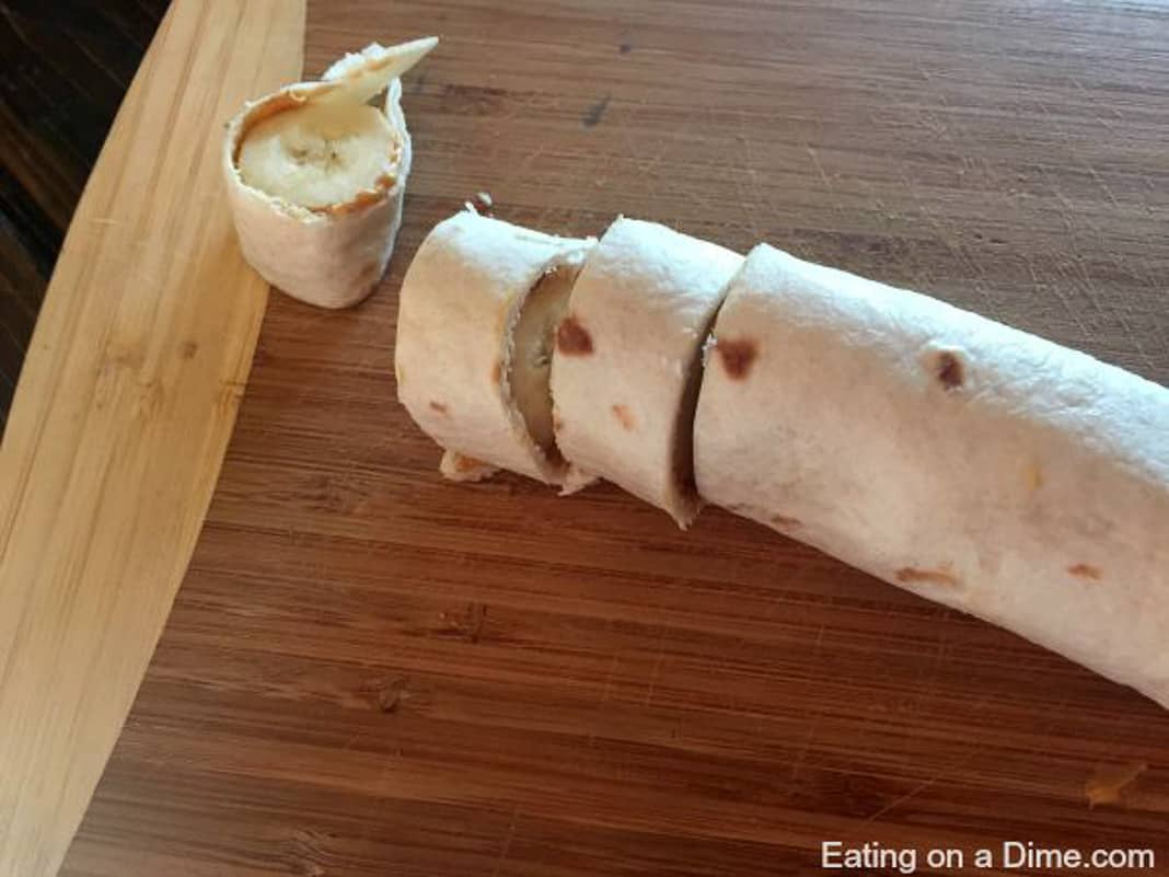 Slicing the banana peanut butter in bite size pieces on a cutting board