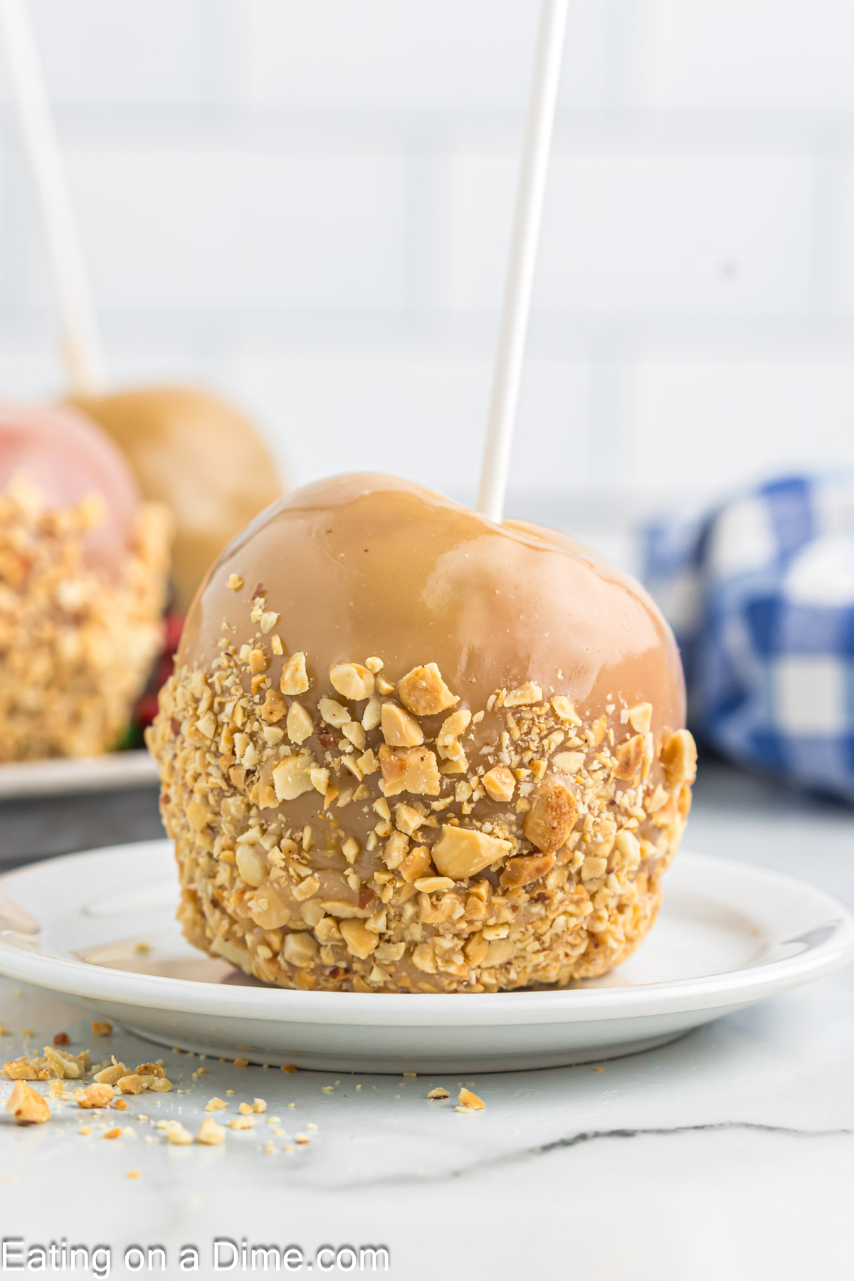 Close up image of caramel apples covered with caramel sauce and chopped nuts