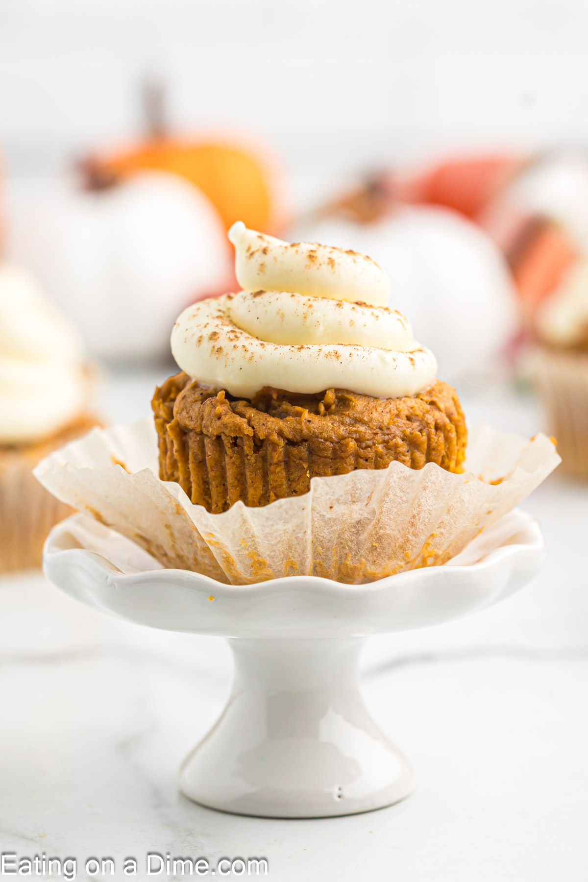 Pumpkin cupcake with cream cheese frosting on a platter