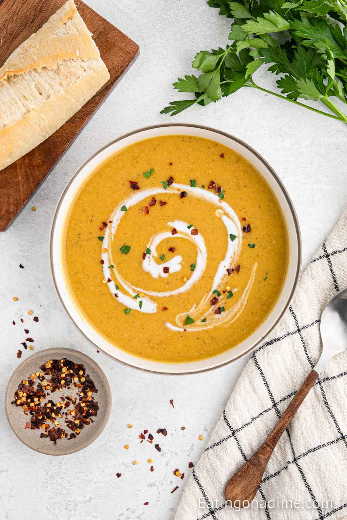 Butternut squash in a bowl topped with cayenne pepper and coconut milk